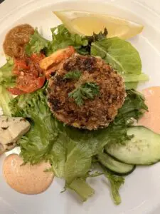 Breaded crab cake on salad with lemon