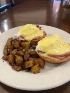 Eggs Benedict with home fries on plate