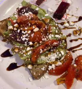 Avocado toast with tomatoes and crumbled cheese